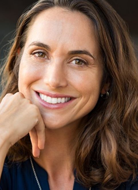 a woman smiling after receiving all-on-4 dental implants