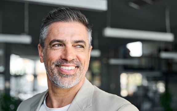 a man smiling while in the workplace