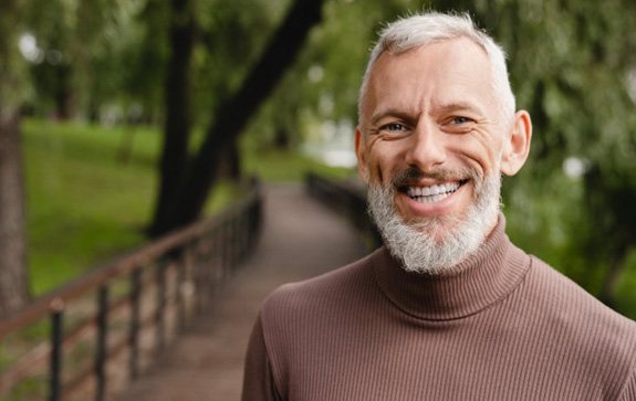 a mature man smiling during a walk outside