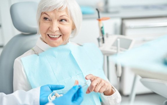 a patient smiling after receiving new dental implants