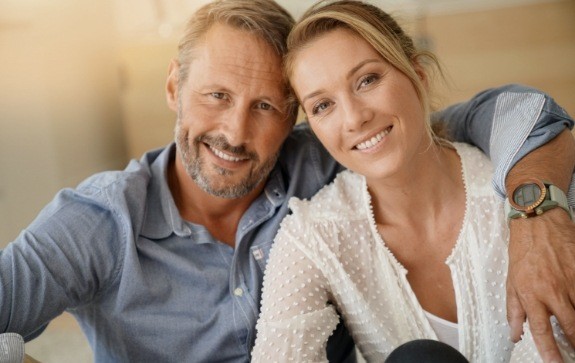 Man and woman sharing flawless smiles after makeovers