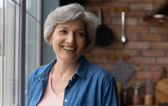 A smiling older woman looking into the distance