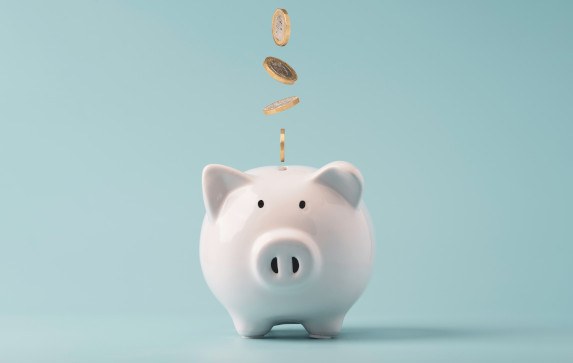 Money falling into a piggy bank