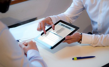 a person holding a digital form for dental insurance