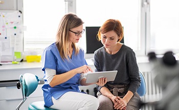 a patient discussing cost of tooth extractions with her dentist