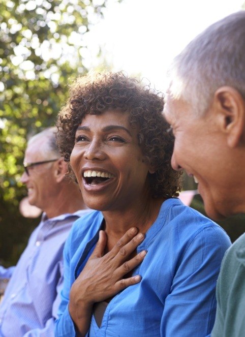 Woman sharing healthy smile after dental implant tooth replacement