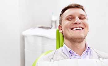 Patient reclined in treatment chair smiling