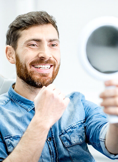 a man admiring his smile in a mirror