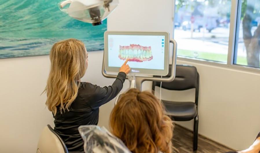 Dental team member and patient looking at smile images