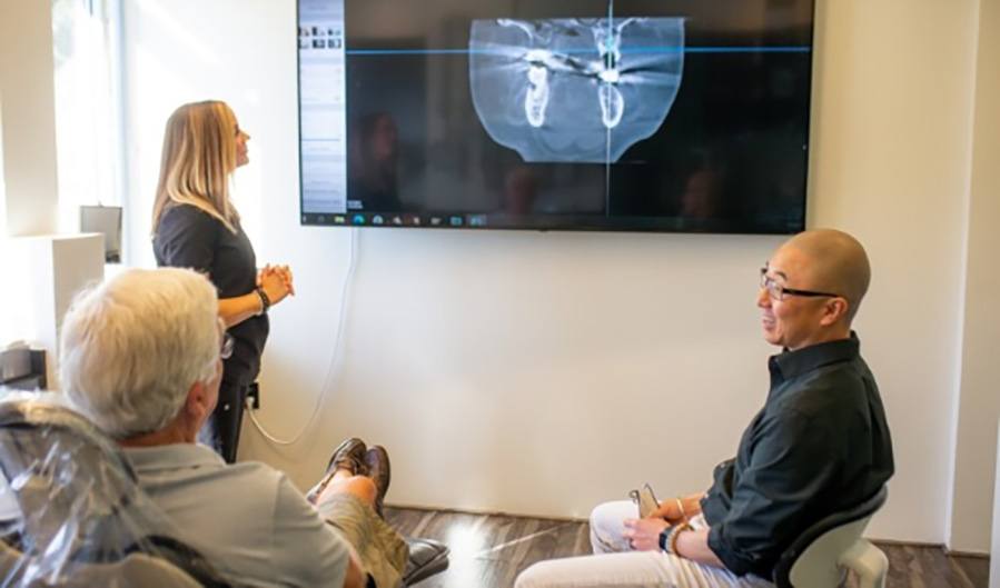 Dentist and patient looking at digital x-rays