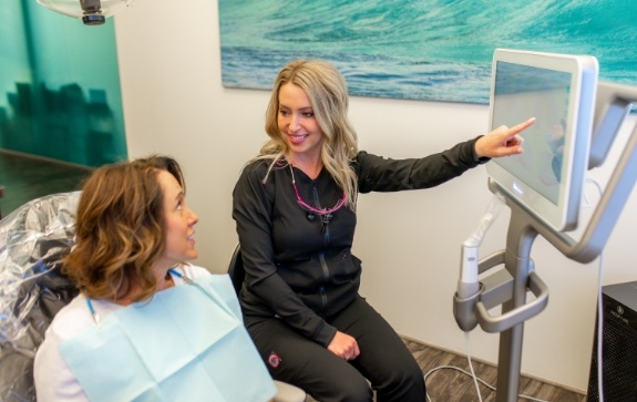 Dental team member and patient talking during dental checkup and teeth cleanings