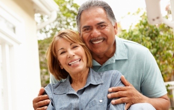 Man and woman smiling after tooth extractions