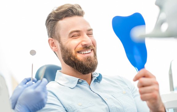 man smiling after paying the cost of veneers in Goodyear