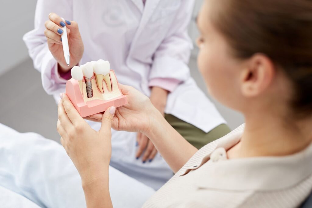 A dentist showing a patient a dental implant